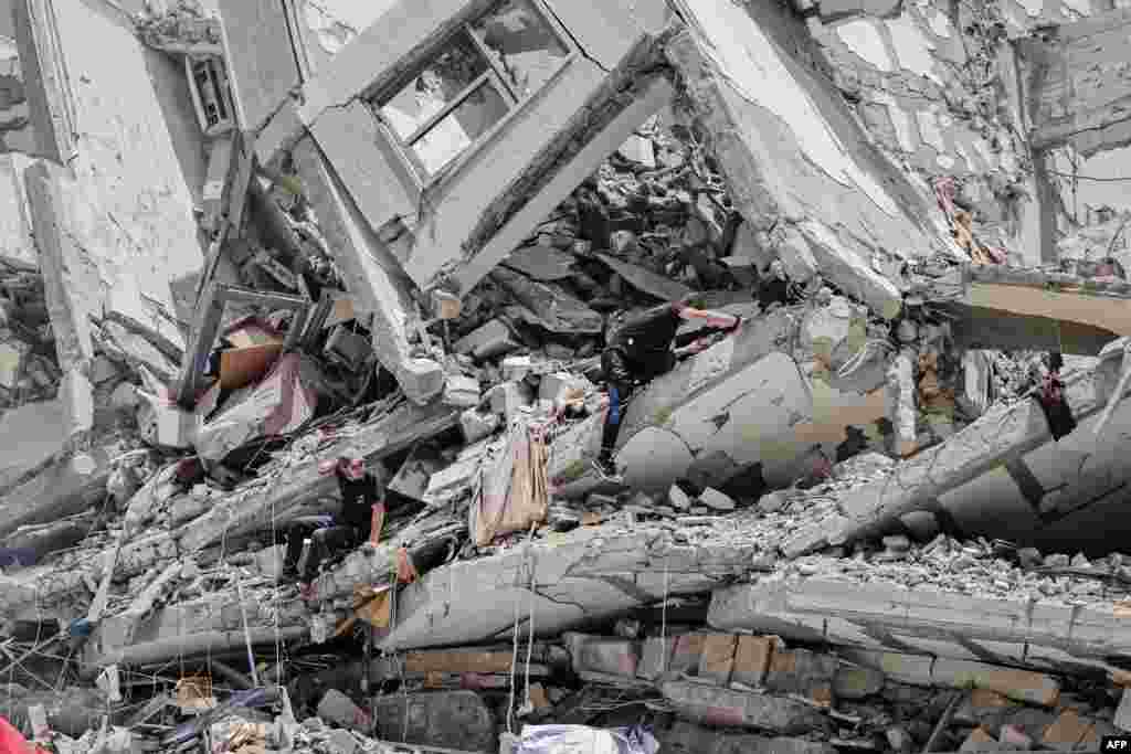 Palestinian workers clear rubble and debris in Gaza City's al-Rimal neighborhood, which was targeted by Israeli strikes during the recent confrontation between Hamas and Israel.