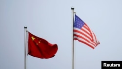 资料照片：美中两国国旗在中国上海的一家公司大楼外飘扬。（2021 年4月14 日）