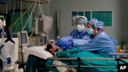 FILE - Medical staff tend to a patient in the emergency COVID-19 ward at the San Carlo Hospital in Milan, Italy, April 16, 2020.