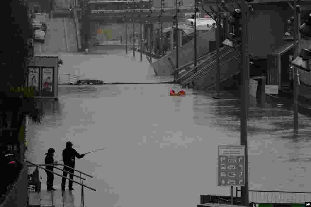 A man and his son fish in the flooded Seine river banks in Paris, France.