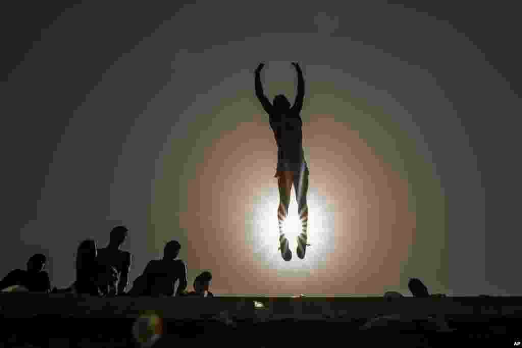 A youth jumps into the Mediterranean Sea off the corniche during a lockdown to curb the spread of coronavirus in Saida, Lebanon, May 2, 2021.