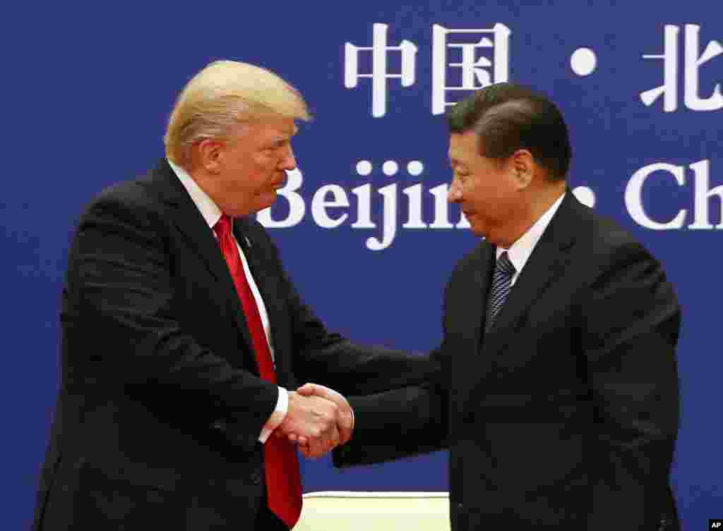 对中国进行国事访问的美国总统川普和中国国家主席习近平在北京人民大会堂出席美中企业家对话会时握手(2017年11月9日)。
