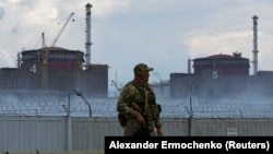 A soldier with a Russian flag on his uniform stands guard near the Zaporizhzhia nuclear power plant outside the Russian-occupied city of Enerhodar on August 4, 2022. REUTERS/Alexander Ermochenko