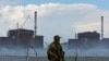 Російські війська захопили Запорізьку атомну електростанцію біля міста Енергодар в Запорізькій області ще на початку теперішнього вторгнення в Україну. На світлині - солдат з російським прапором на грудях стоїть біля загорожі Запорізької АЕС 4 серпня 2022 р.
