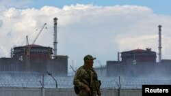 Російські війська захопили Запорізьку атомну електростанцію біля міста Енергодар в Запорізькій області ще на початку теперішнього вторгнення в Україну. На світлині - солдат з російським прапором на грудях стоїть біля загорожі Запорізької АЕС 4 серпня 2022 р.