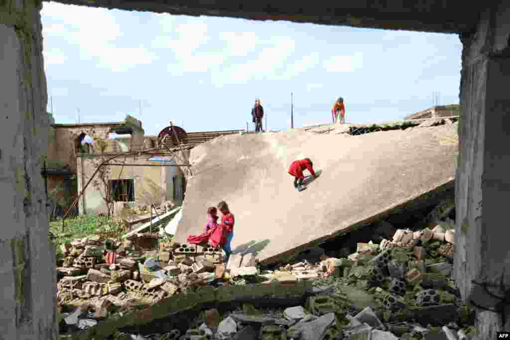 Syrian children play outside their destroyed school in the Frikeh village, in Idlib's Western countryside.