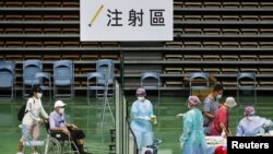 台湾医护人员在新北市的一个体育馆为85岁以上的老人接种新冠疫苗。（2021年6月15日）