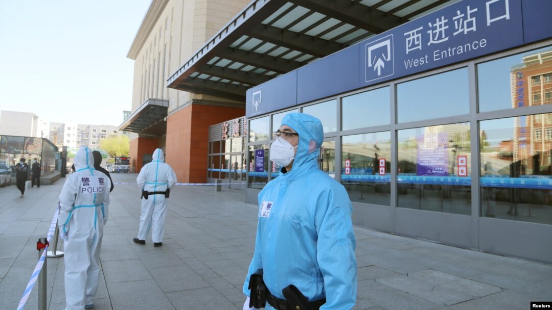 中國吉林省吉林市身穿防護服的警察站在停運的火車站進站口處。（2020年5月13日）