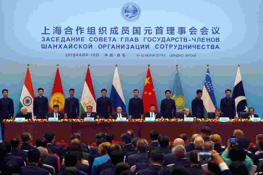 在青岛举行的上海合作组织成员国首脑会议主席台(2018年6月10日)。关于人名,请参阅上面那张8位领导人合影,两图人物排列顺序一致。日本时报(Japan Times)刊登英国议会上院国际关系委员会主席戴维·豪厄尔勋爵的文章指出,西方自由主义者迄今一直对上海合作组织表示不屑一顾,首先,该组织被看作是一个相当薄弱的架构,缺乏一个像欧盟或较为宽松的北约组织那样坚定的中央协调和指导体系。其次,就共同目标而言,上合组织被广泛地视为反西方和反美,因此被以怀疑的视角来看待。不过文章指出,相互敌对的印度和巴基斯坦现在都是上合组织成员,伊朗也得到邀请。上海合作组织正在成为一个拥有几乎世界一半人口的团体,成为巨大的网络。
