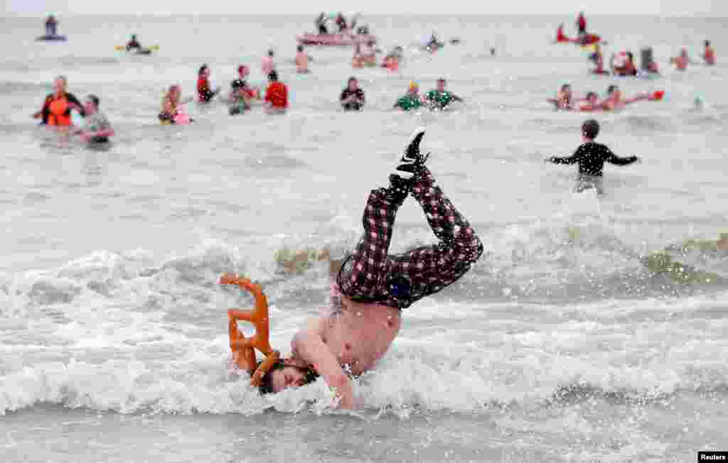 A participant jumps in the waters of the North Sea during the annual New Year's plunge event in Ostend, Belgium, Jan. 6, 2018.