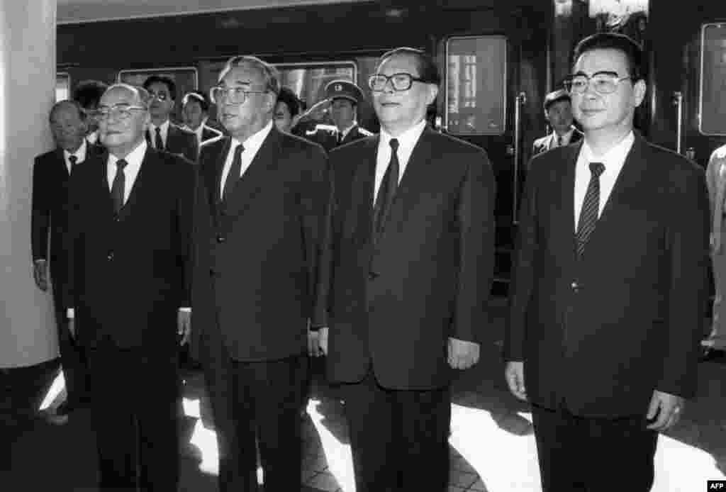 1991年10月4日朝鲜领导人金日成抵达北京火车站,在欢迎仪式上演奏国歌时,和中国领导人一起肃立。右起:中国总理李鹏,中共总书记江泽民,金日成,中国国家主席杨尚昆。1989年六四镇压以后,邓小平将军委主席交给江泽民,杨尚昆出任军委第一副主席,杨白冰升任中央书记处书记兼军委秘书长,掌握军队实权。此时的“杨家将”权力达到顶峰,而江泽民则备受钳制。