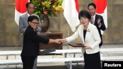 2023年12月16日，日本外相上川洋子和印度尼西亚外长蕾特诺在日本东京首相官邸举行的文件交换仪式上握手。(路透社）