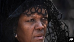 Grace Mugabe wears a black veil as she follows the casket of former president Robert Mugabe to an air force helicopter for transport to a stadium where it will lie in state, at his official residence in the capital Harare, Zimbabwe, Sept. 12, 2019.