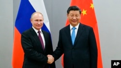 俄罗斯总统普京与中国国家主席习近平2019年11月12日在巴西巴西利亚金砖国家峰会期间会面时握手