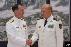 美国海军作战部长理查森和中国海军司令吴胜利在北京的中国海军总部握手（2016年7月18日）