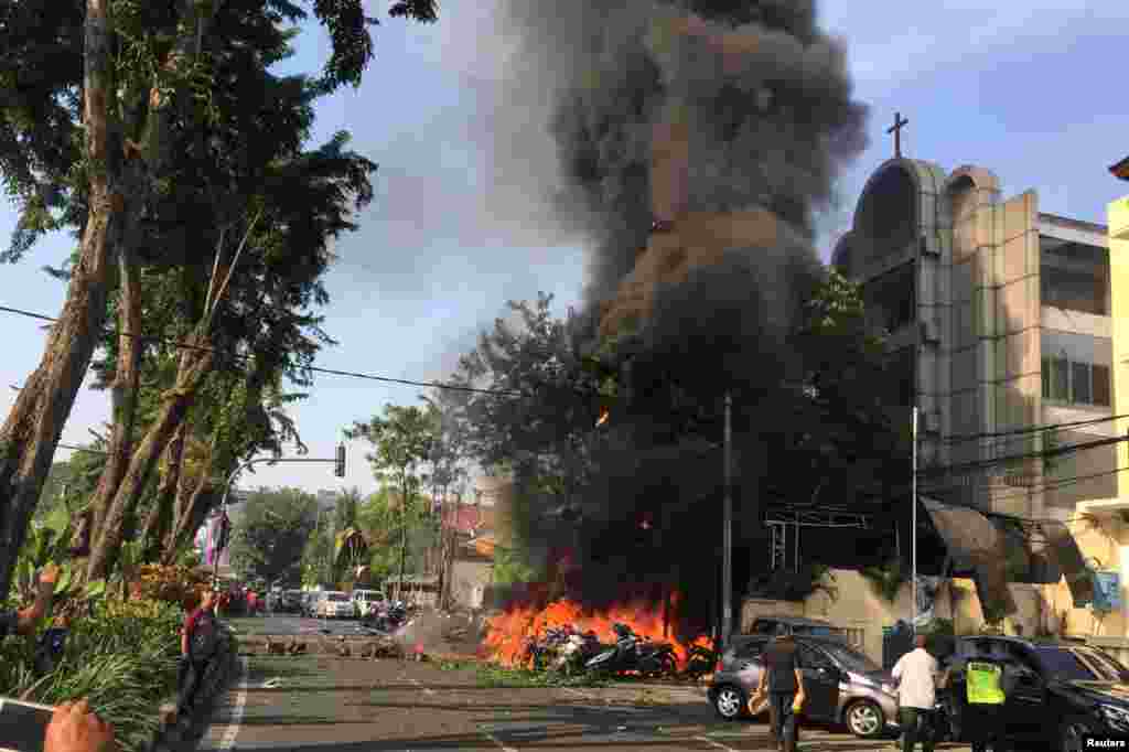 Motorcycles burn following a blast at the Pentecost Church Central Surabaya (GPPS), in Surabaya, East Java, Indonesia, in this photo provided by Antara Foto.