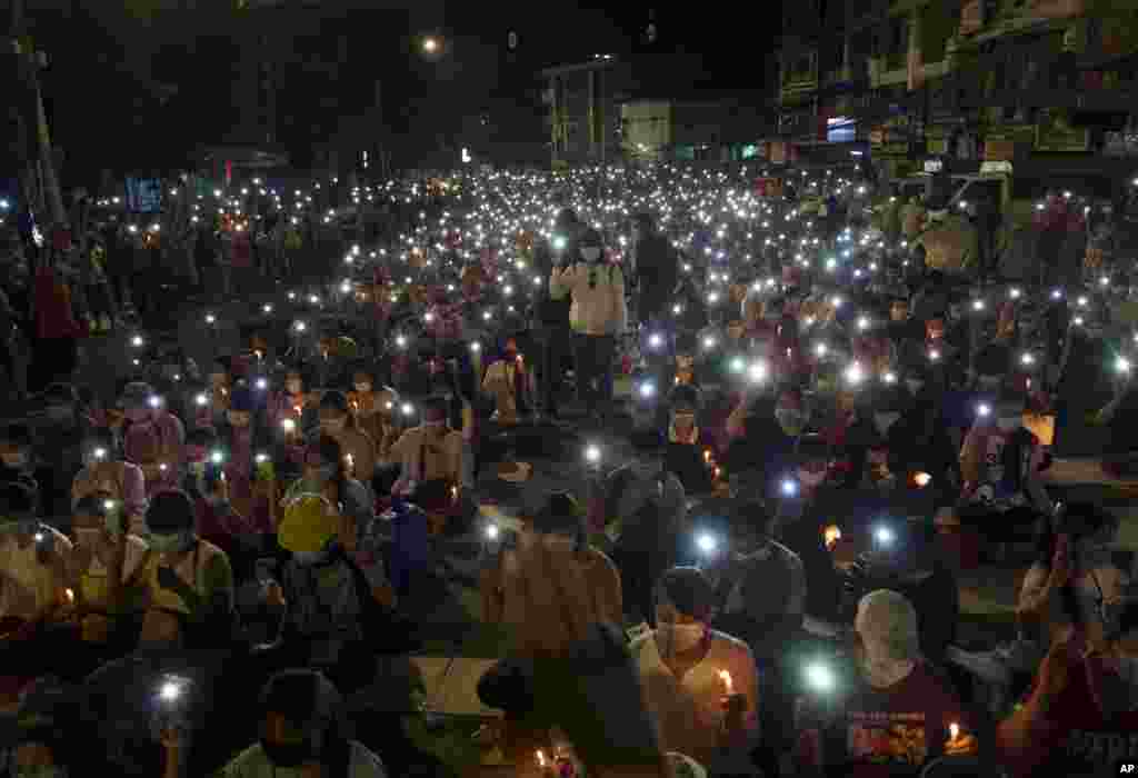 Anti-coup protesters turn on the LED light of their mobile phones during a candlelight night rally in Yangon, Myanmar.