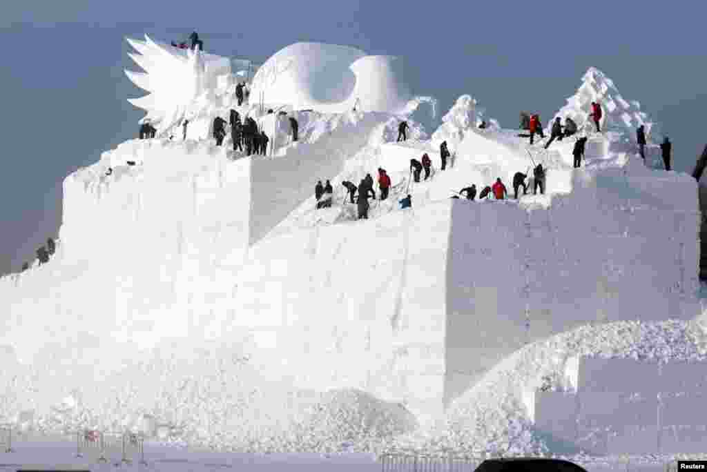 哈尔滨的一座正在雕刻的大型雪雕。一年一度的哈尔滨国际冰雪节即将开幕，准备工作正在进行。（2017年12月6日）