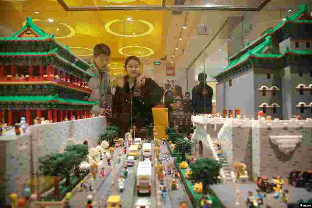 在北京的乐高授权专卖店,顾客观赏玩具北京城的前门和公路(2018年1月13日)。