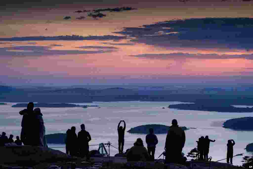 Early-rising visitors to Acadia National Park await the sunrise on the summit of Cadillac Mountain, near Bar Harbor, Maine.