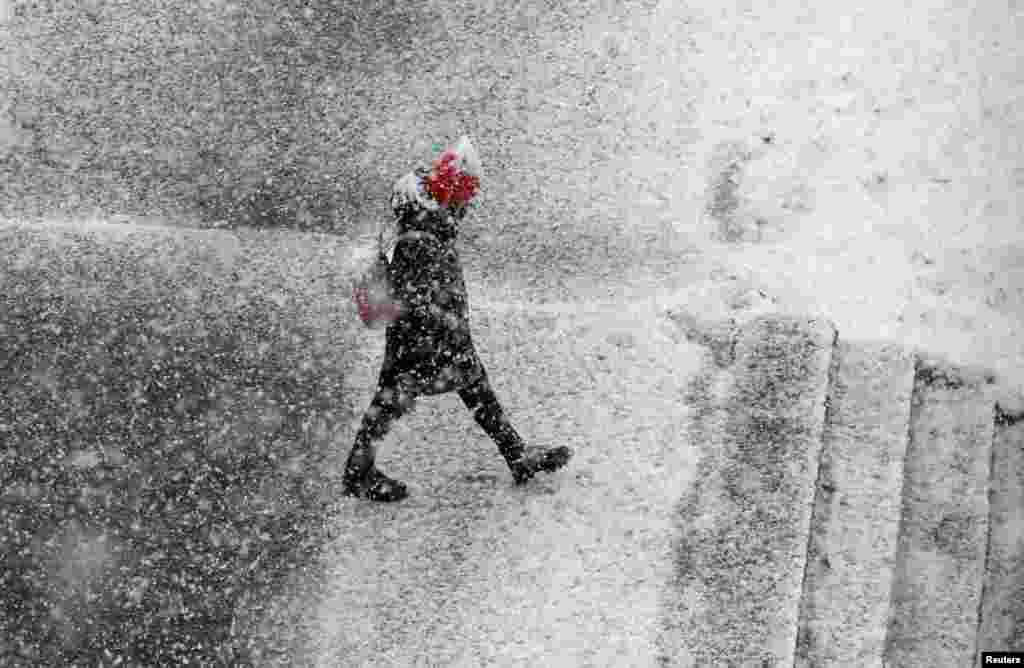 A pedestrian walks during a heavy snowfall in the Siberian town of Divnogorsk, Russia.
