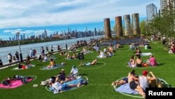 2020年5月16日纽约布鲁克林多米诺公园人们保持社交距离享受阳光。