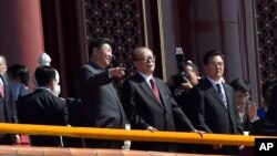 在“纪念中国人民抗日战争暨世界反法西斯战争胜利70周年”阅兵时，中国主席习近平和前主席江泽民交谈。胡锦涛在旁边（2015年9月3日）
