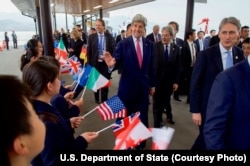 美国国务卿克里抵达日本，向欢迎他的儿童们招手致意（2016年4月10日）