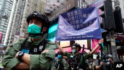 在中国共产党建立政权周年纪念日，一名警察在香港铜锣湾打出警告旗。(2020年10月1日)