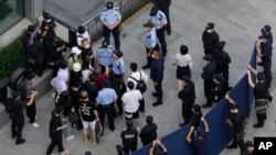一些投资者2021年9月下旬到深圳恒大总部抗议时被警察和保安阻拦。