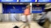 File - Passengers walk past a South African Airways (SAA) customer desk at the O.R. Tambo International Airport in Johannesburg, South Africa, Jan. 21, 2020. 