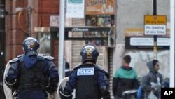 图为英国防暴警察8月9日在曼彻斯特追赶打劫商店的人