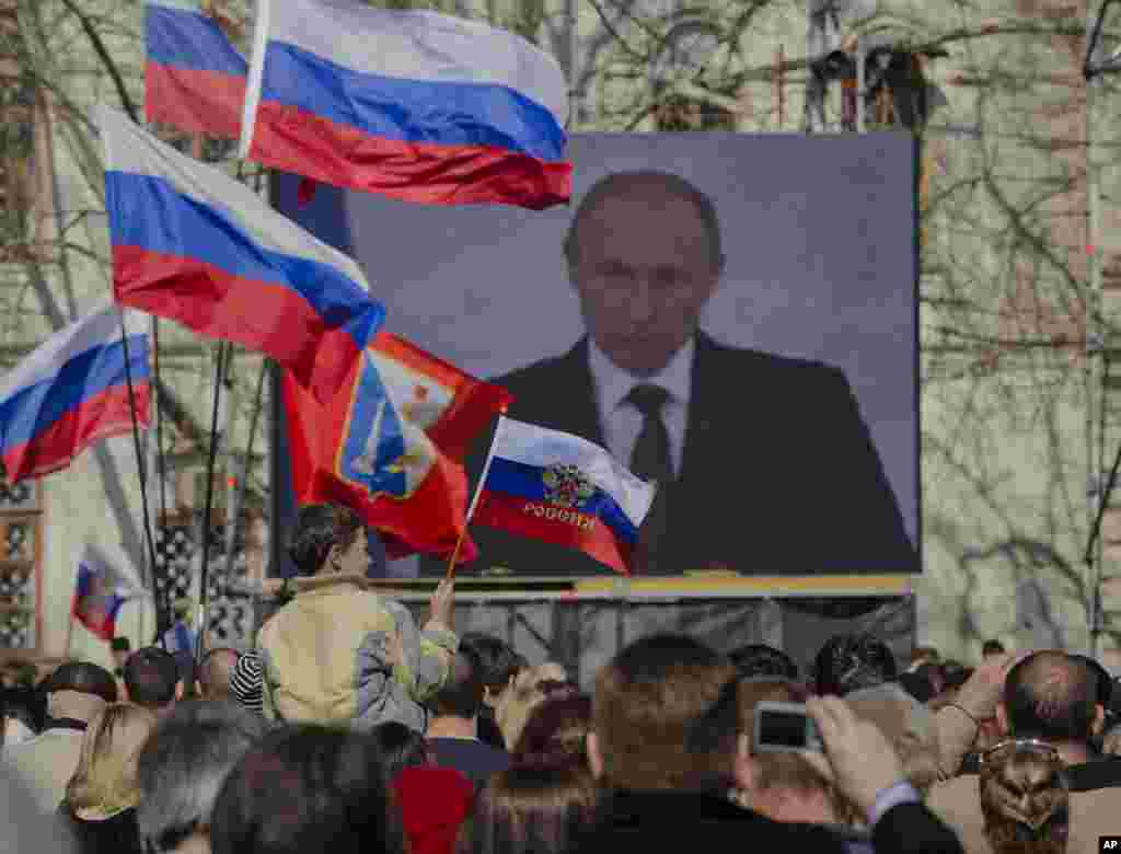 Những người thân Nga theo dõi bài phát biểu của Tổng thống Putin trên truyền hình tại bán đảo Crimea, ngày 18/3/2014.