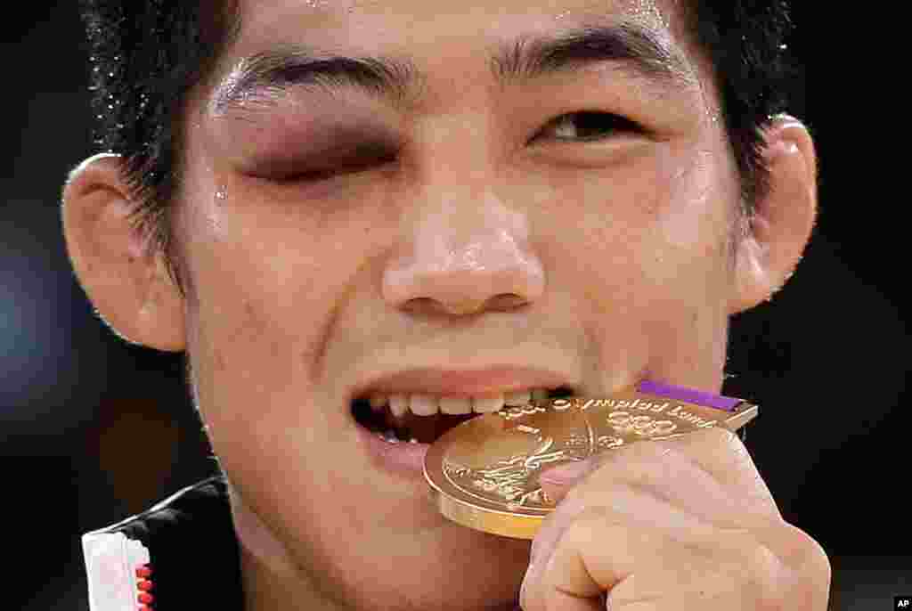 Vận động viên Nam Triều Tiên Kim Hyeon-woo đứng trên khán đài chiến thắng sau khi hạ Tamas Lorincz của Hungary giành chiếc huy chương vàng môn đấu vật cổ điển hạng cân 66 kg