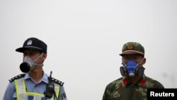 在天津大爆炸现场头带防毒面具的中国警察和武警士兵 （2015年8月18日）