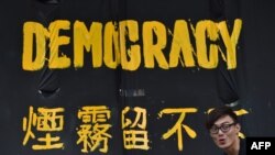 一名香港民主派抗议者站在横幅前。（2014年9月30日资料照）