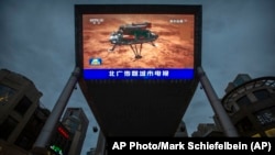北京街头一家商场的大屏幕正在播放中国官媒报道中国火星探测器天问一号成功登陆火星的视频。（2021年5月15日）