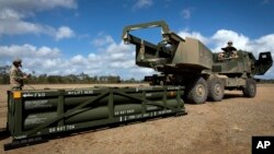 Американські військові 3-го полку польової артилерії 17-ї бригади готують кран для завантаження ракетних систем на високомобільну артилерійську ракетну систему HIMARS. Фото: сержант Ендрю Діксон/через AP)