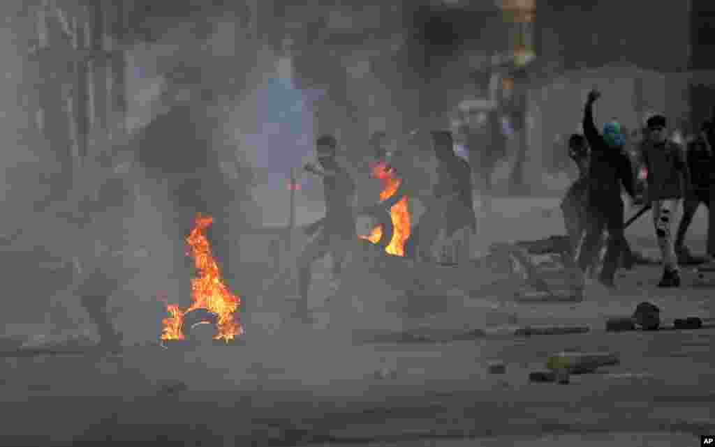 Kashmiri Muslim protesters throw stones at Indian policemen during a protest in Srinagar, Indian-controlled Kashmir.