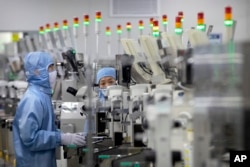 在这张 2020 年 5 月 14 日的档案照片中，在政府组织的北京记者参观活动中，身穿防护装备的员工在瑞萨电子的一家半导体生产工厂工作。