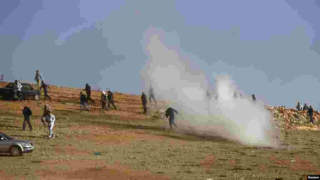 Binh sĩ Thổ Nhĩ Kỳ bắn hơi cay giải tán những người Kurd tụ tập xem trận chiến ở Kobani trên một ngọn đồi gần cửa khẩu Mursitpinar trên biên giới Thổ Nhĩ Kỳ-Syria, ngày 26/10/2014. 