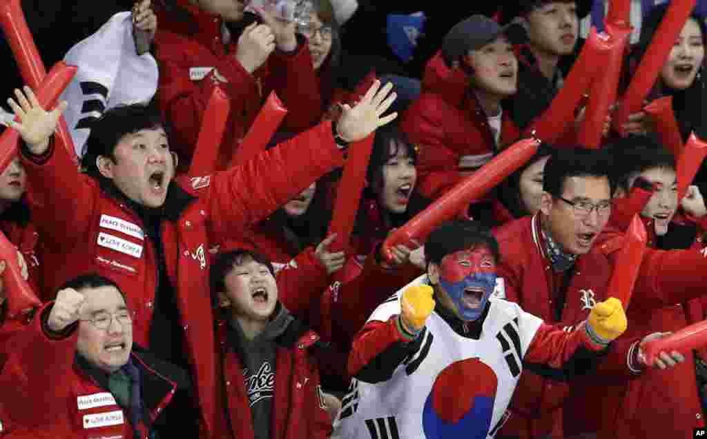 South Koreans celebrate as their fellow countryman Lee Seung-hoon competes during the men's 10,000 meters speedskating race at the Gangneung Oval at the 2018 Winter Olympics in Gangneung, South Korea.