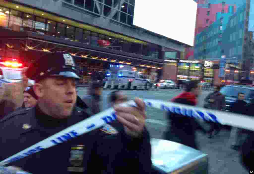 纽约警察正在市中心时报广场附近的爆炸现场设置警戒线(2017年12月11日)。12月11日早上纽约市发生爆炸事件,一名嫌犯被警方拘留,包括嫌犯在内4人受伤。爆炸地点靠近时报广场和港务总局巴士站,在连接两条地铁线的地下通道里。