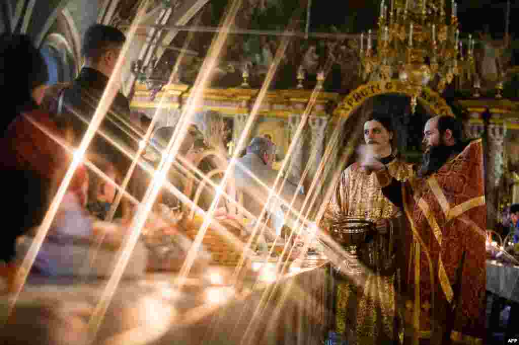 An Orthodox priest blesses cakes and colored eggs during an Orthodox Easter ceremony in the Holy Trinity-St.Sergius Lavra in Sergiyev Posad, Russia, April 7, 2018.