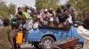 Mutanen kauye a zaune a bayan wata mota a lokacin da suke tserewa rigingimu a kusa da birnin Maiguduri. 
