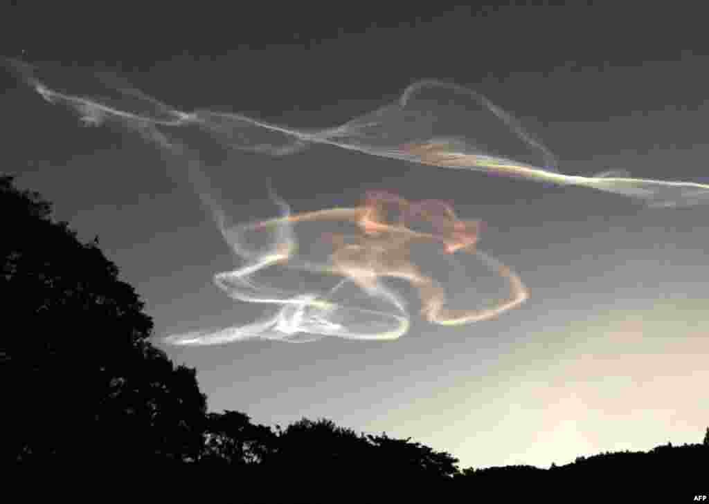 Smoke trails made by an Epsilon rocket are seen during the morning sunrise over Kimotsuki town in Kagoshima prefecture, Japan. The Epsilon rocket, carrying the ASNARO-2 radar satellite developed by NEC, was launched from the JAXA Uchinoura Space Center.