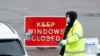 A NHS worker passes a COVID-19 test kit to a driver at a mobile test center, amid the coronavirus outbreak, in Broxbourne, Hertfordshire, Britain, Feb. 2, 2021. 