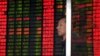An investor stands in front of an electronic board showing stock information at a brokerage house in Shanghai, China, Sept. 2, 2015. 