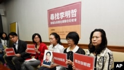 台湾人权活动人士李明哲的妻子李净瑜在台北的记者会上手持李明哲的照片，非政府组织的代表们也参加了记者会（2017年3月24日）