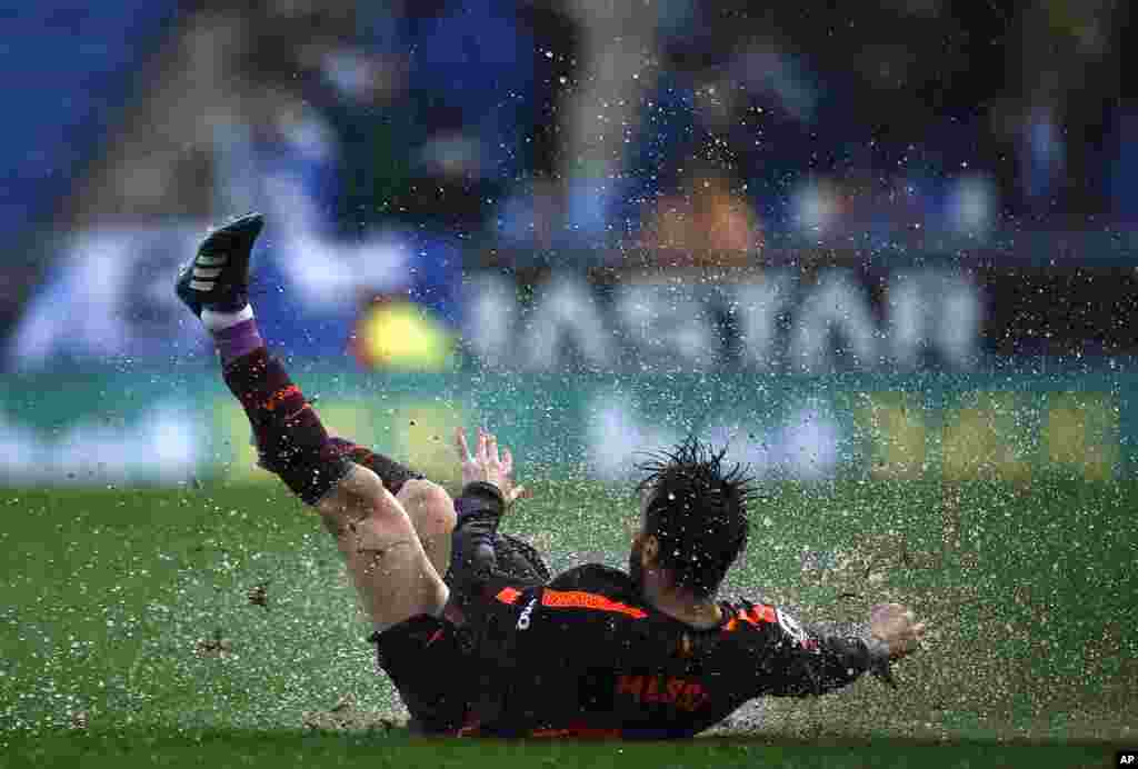 FC Barcelona's Lionel Messi falls during the Spanish La Liga soccer match between Espanyol and FC Barcelona at RCDE stadium in Cornella Llobregat, Spain.